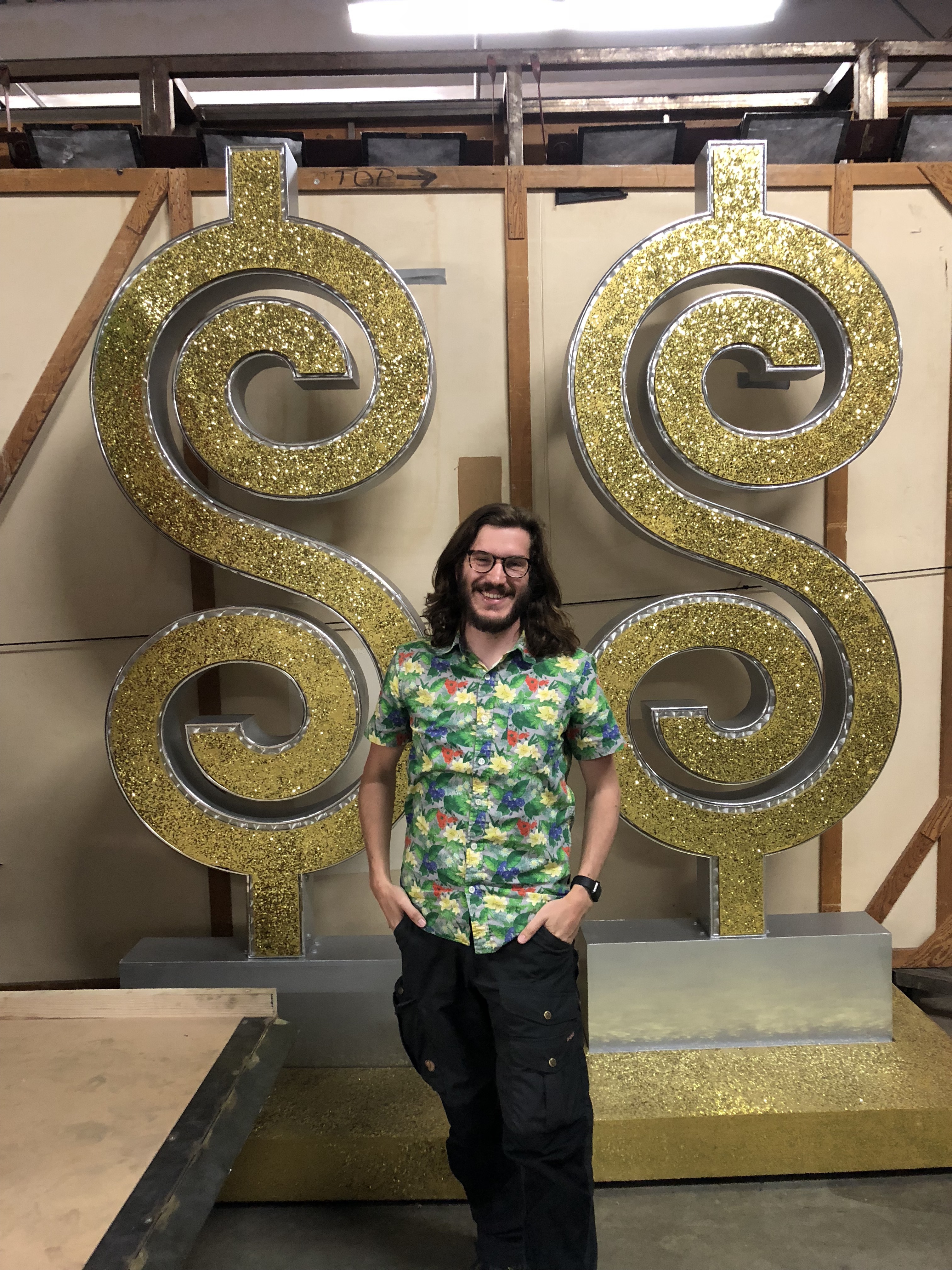Dana in front of some dollar signs